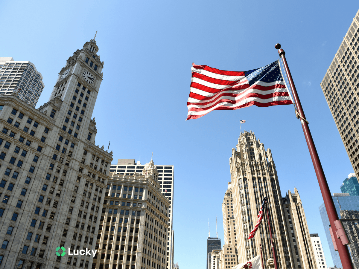 Amerykańska flaga na tle architektury Chicago – dowiedz się, ile kosztuje bilet do usa i jak tanio podróżować.